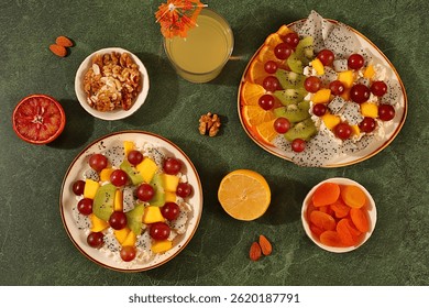 Kitchen background with fruit salads with soft grain cottage cheese, yogurt, dragon fruit, kiwi, mango, oranges, nuts, orange juice and grapes. Healthy light breakfast with ingredients,