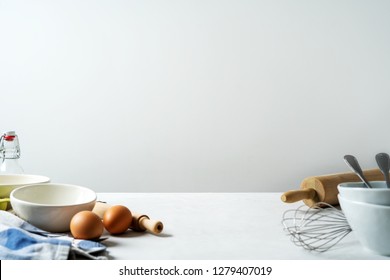 Kitchen background for mockup with eggs, rolling pin, bowl for cooking and baking utensils on table on white background - Shutterstock ID 1279407019