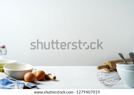 Kitchen background for mockup with eggs, rolling pin, bowl for cooking and baking utensils on table on white background