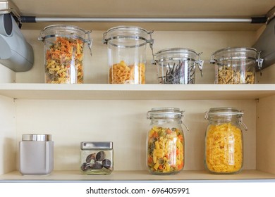Kitchen cabinet with opened fronts with kitchen bench shelves with various food ingredients on white background
