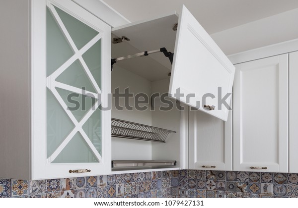 Kitchen cabinet with opened fronts with dish holder shelves inside