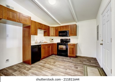 Kitchen Cabinets With Black Appliances And White Tile Wall Trim