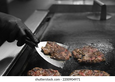 A Kitchen Chef Flips Homemade Burger Patties On A The Grill