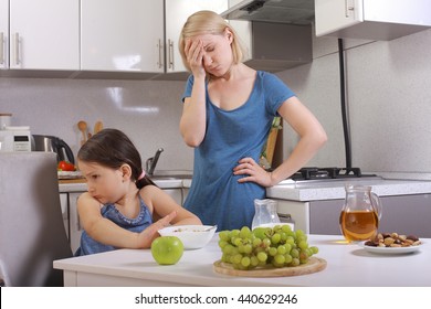 in the kitchen. a child refuses to eat, mom makes daughter eat healthy. mom and daughter eating Breakfast, the child is not eating. quarrels, conflicts in the family. offers baby. frustrated mom