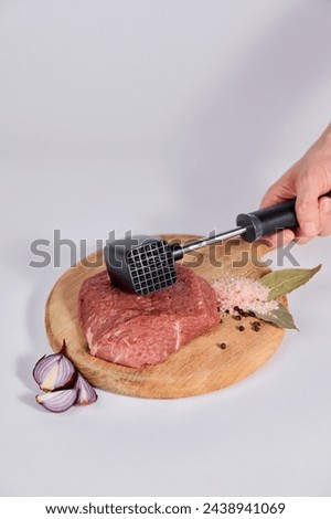 Kitchen concept, hammer for beating meat on a board.