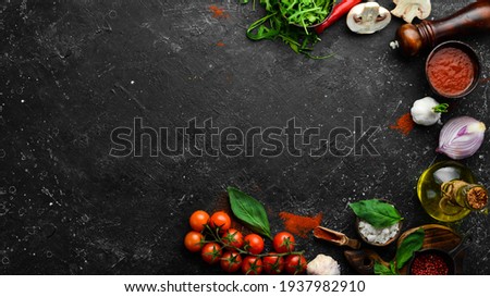 Kitchen cooking background: cherry tomatoes, onions, spices and herbs. On a black background. ストックフォト © 