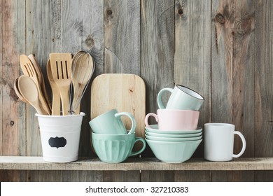 Kitchen cooking utensils in ceramic storage pot on a shelf on a rustic wooden wall - Powered by Shutterstock