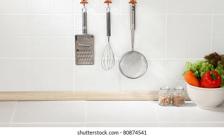 Kitchen Cooking Utensils On Hook Against Tile Wall