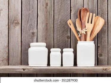 Kitchen Cooking Utensils On Shelf Against Rustic Wooden Wall