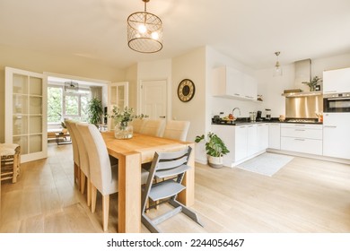 a kitchen and dining area in a house with white walls, hardwood flooring and an open plan living room - Powered by Shutterstock