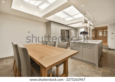 a kitchen and dining area with skylights on the ceiling over the island, which has been used as an extension