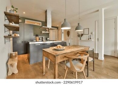 a kitchen and dining area in a small apartment with wood flooring, white walls and light green pendants on the ceiling - Powered by Shutterstock