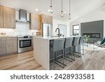 Kitchen and dining room interior with light colors aqua blue hardwood flooring grey chairs bar stools kitchen island stainless appliances and large windows