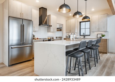 Kitchen and dining room interior with light colors aqua blue hardwood flooring grey chairs bar stools kitchen island stainless appliances and large windows - Powered by Shutterstock