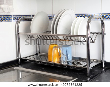 Kitchen, dish rack with clean plates and cups. The concept of cleanliness and comfort