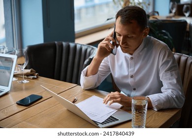 Kitchen employee communicates with suppliers via mobile phone - Powered by Shutterstock