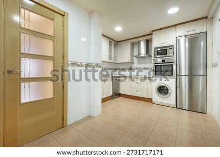Kitchen of an empty apartment except for kitchen cabinets and column appliances