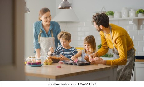 In the Kitchen: Family of Four Cooking Muffins Together. Mother and Daughter Mixing Flour and Water to Create Dough for Cupcakes, Father, Son Preparing Paper Lines for Pans. Children Helping Parents - Powered by Shutterstock