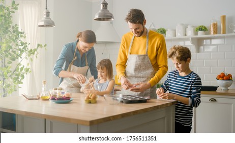 In the Kitchen: Family of Four Cooking Muffins Together. Mother and Daughter Mixing Flour and Water to Create Dough for Cupcakes, Father, Son Preparing Paper Lines for Pans. Children Helping Parents - Powered by Shutterstock
