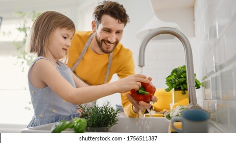 In Kitchen: Father And Little Daughter Cooking Together Healthy Dinner. Dad Teaches Little Girl Importance Of Washing Hands And Healthy Eating Habits. Cute Child Helping Her Beautiful Caring Parents