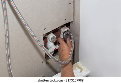 Kitchen Faucet Installation. The Plumber Fixes The Flexible Pipe Connection With An Adjustable Wrench. Repair In The House.