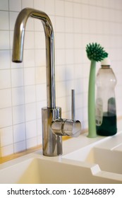Kitchen faucet on a white wall background.  Close-up