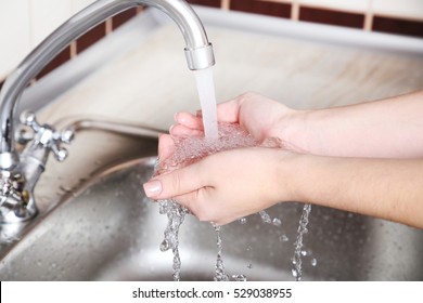 Kitchen Faucet With The Running Water In Female Hands
