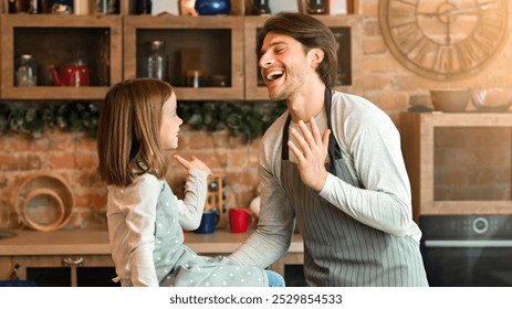 Kitchen Fun. Young Father And His Little Daughter Laughing While Cooking Together At Home, Enjoying Baking, Having Family Time, Giving High-Five To Each Other, Preparing Homemade Pastry, Free Space - Powered by Shutterstock