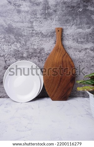 kitchen furniture consisting of wooden trays and white plates. cement pattern background