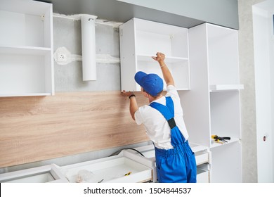 Kitchen Installation. Worker Assembling Furniture