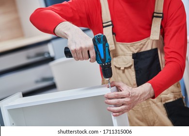 Kitchen Installation. Worker Assembling Furniture