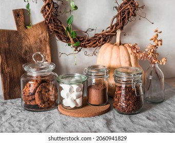 Kitchen interior - cans of cookies, granola, cocoa, marshmallows on the table. Cozy home concept     