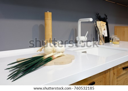 Kitchen interior, glass jars with grains in modern kitchen with white mixer, green onion, garlic, spices, wooden chopping board; white table top, interior of modern kitchen Stock fotó © 