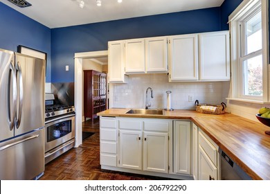 Kitchen Interior With White Cabinets And Bright Navy Walls