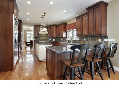 Kitchen With Island And Dark Tile Backsplash