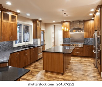 Kitchen With Island, Sink, Cabinets, And Hardwood Floors