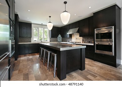 Kitchen In Luxury Home With Dark Wood Cabinetry