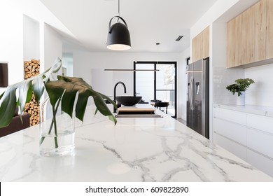 Kitchen marble bench close up with black hanging pendant and vase