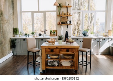 Kitchen Modern Interior with Ancient Wooden Table and Chairs. Shelf with Flatware and Green Plants in Pot, Bread in Wicked Basket, Fruit and Grape on Decorative Plate. Light Room with Grunge Walls - Powered by Shutterstock