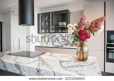 Kitchen in new luxury home with granite quartz table with bouquet of flowers