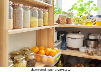 Kitchen Pantry, Wooden Shelves With Jars And Containers With Food, Food Storage. Jars Of Cereals, Container Of Oranges, Kitchen Utensils, Houseplants