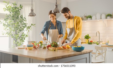 In Kitchen: Perfectly Happy Couple Preparing Healthy Food, Lots of Vegetables. Man Juggles with Fruits, Makes Her Girlfriend Laugh. Lovely People in Love Have Fun - Powered by Shutterstock