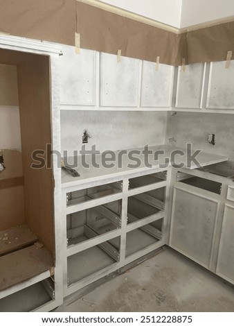 Kitchen remodel in progress with priming the cabinets and placing the granite