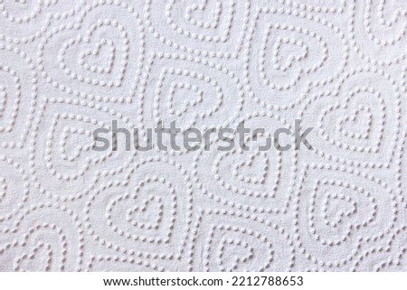 Kitchen roll texture full frame. Closeup view of embossed surface texture of new white paper towel tissue from roll in heart-shape pattern.