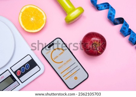 kitchen scale, phone with a calorie counting application, fruit and a tape measure in a flat lay photo. Concept showing diet and healthy eating. Taking care of your physical shape