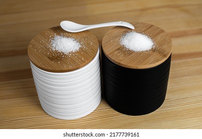 A kitchen set that includes sugar, pepper and salt with a spoon
