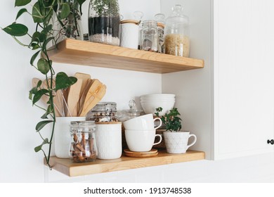 Küchenschränke mit verschiedenen weißen Keramik- und Glaskeramik. Offene Regale in der Küche. Kücheninnere Ideen. Öko-freundliche Küche, Konzept von Null-Abfall-Zuhause