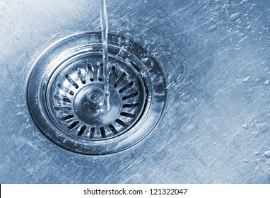 Kitchen Sink Closeup. Water Running Into The Drain.