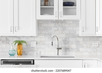 A Kitchen Sink Detail Shot With White Cabinets, Marble Subway Tile Backsplash, And Cozy Decor.