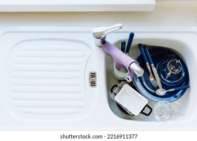 Kitchen Sink Is Filled With Dirty Dishes. View From Above. Unwashed Dishes After Lunch Or Dinner In Sink, High Angle View.  Concept Of Lack Of Time, Home Routine, Need For Dishwasher